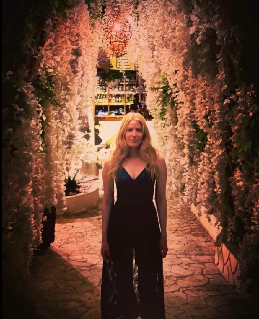 Woman in floral tunnel under warm lights